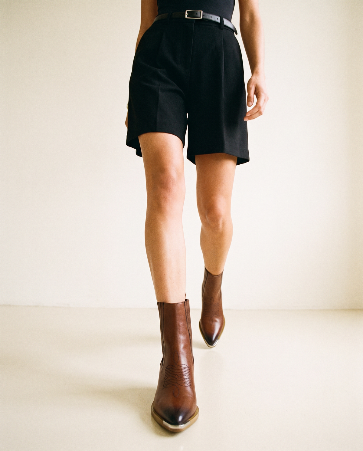 ASADLIE Nella brown leather Chelsea ankle boots on a model walking toward the camera, front view with metal detail